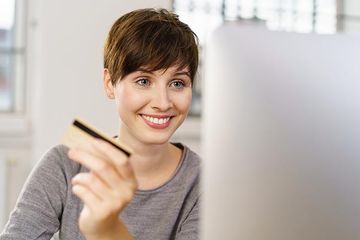 Frau hat das Brautkleid in den Karton getan und schließt die Bestellung online ab.